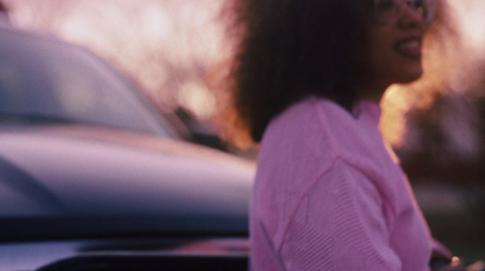 a woman standing next to a car in a parking lot