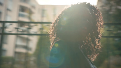 a woman with long hair standing in front of a building