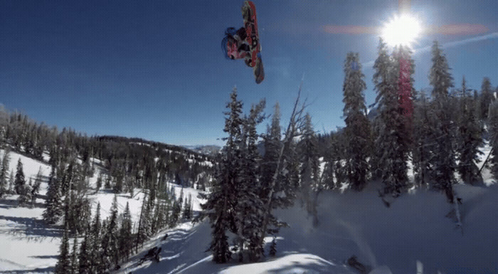 a man flying through the air while riding a snowboard