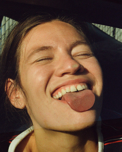 a woman sticking her tongue out of a car window