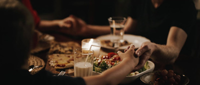 a group of people sitting at a table with plates of food