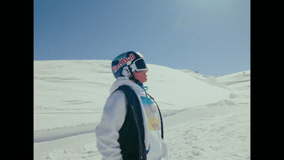 a man standing in the snow wearing a snowboard helmet