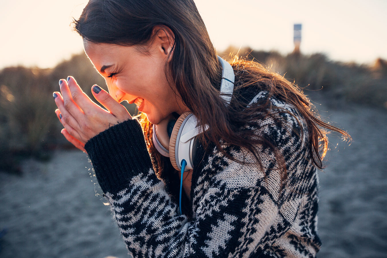 a woman in a black and white sweater holding her hands together