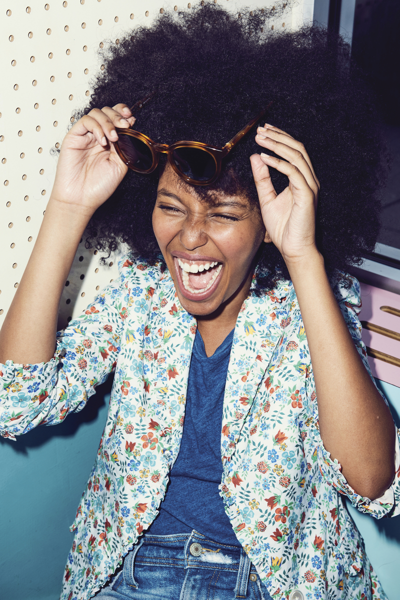 a woman with an afro is holding her hair in the air