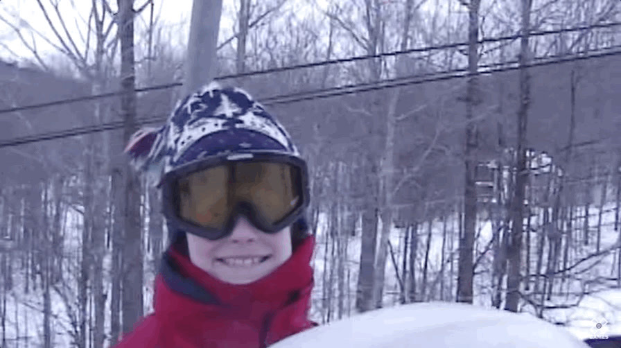 a young person holding a snowboard in the snow