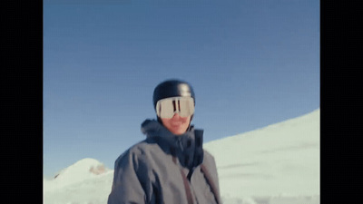 a man standing in the snow wearing a ski mask