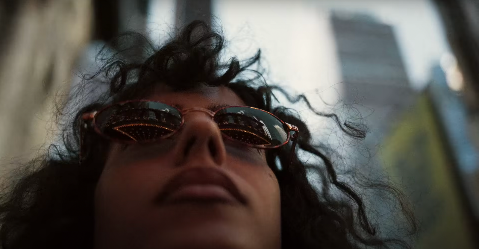 a man with long curly hair wearing sunglasses