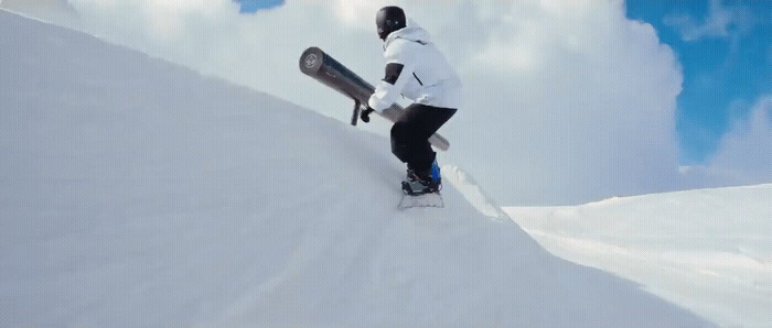 a man riding a snowboard down a snow covered slope