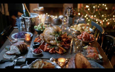 a table full of food with a christmas tree in the background