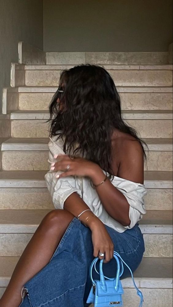 a woman sitting on the steps with a handbag