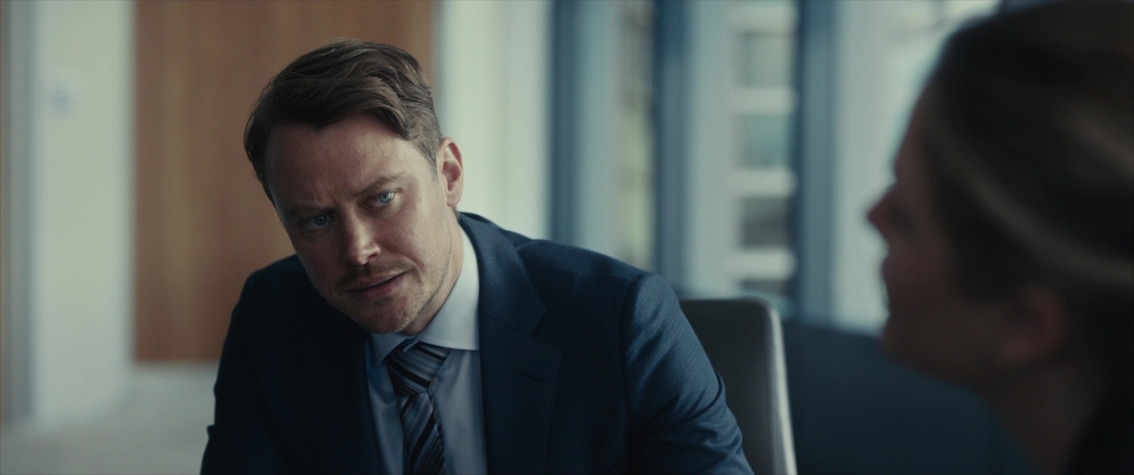 a man in a suit and tie sitting at a table