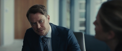 a man in a suit and tie sitting at a table