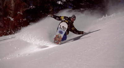 a man riding a snowboard down a snow covered slope