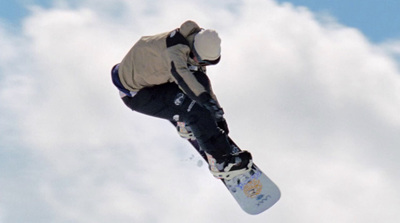 a man flying through the air while riding a snowboard