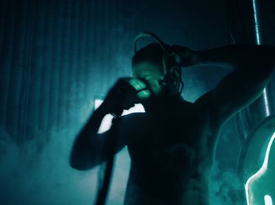 a man holding a guitar in a dark room