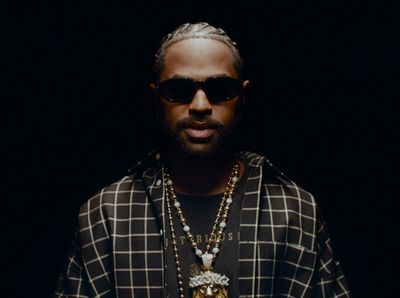 a man with a beard wearing a necklace and sunglasses