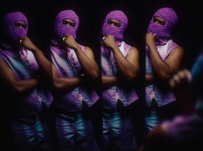 a group of people wearing purple outfits and covering their faces