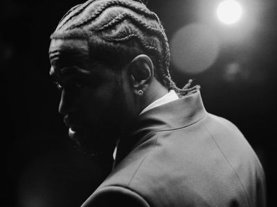 a man with dreadlocks standing in front of a spotlight