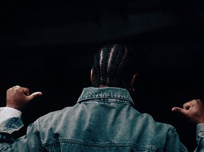 a man in a denim jacket pointing at something