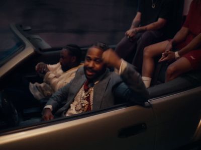 a man in a suit sitting in the back of a car