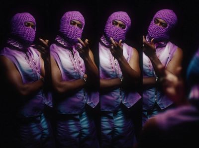 a group of women wearing purple outfits and covering their faces