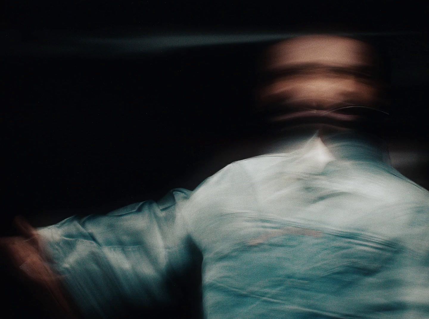 a blurry image of a man in a white shirt