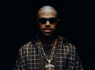 a man with a beard wearing sunglasses and a necklace