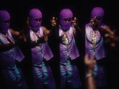 a group of people wearing purple clothing and head coverings