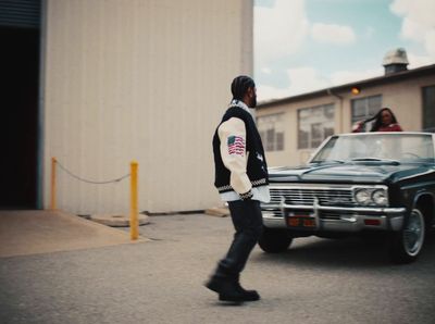 a man walking down a street next to a car