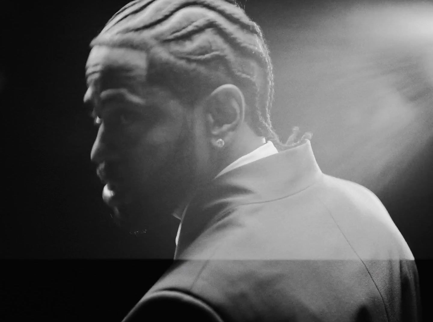 a black and white photo of a man with dreadlocks