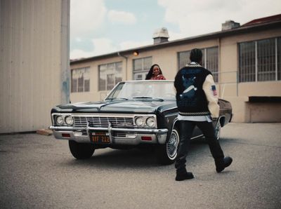 a man and a woman standing next to a car