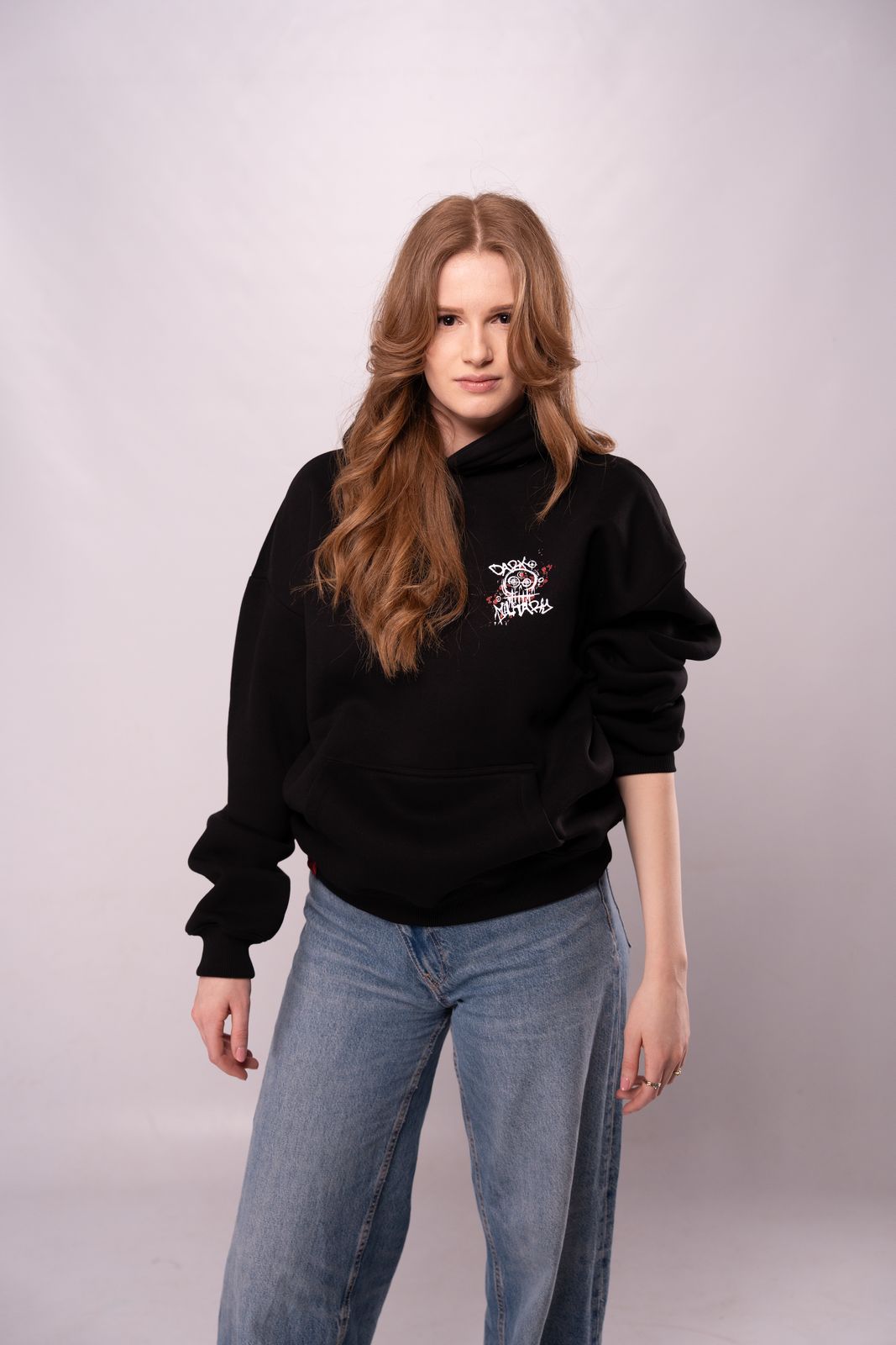 a woman wearing a black sweatshirt and jeans