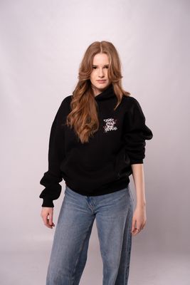 a woman wearing a black sweatshirt and jeans