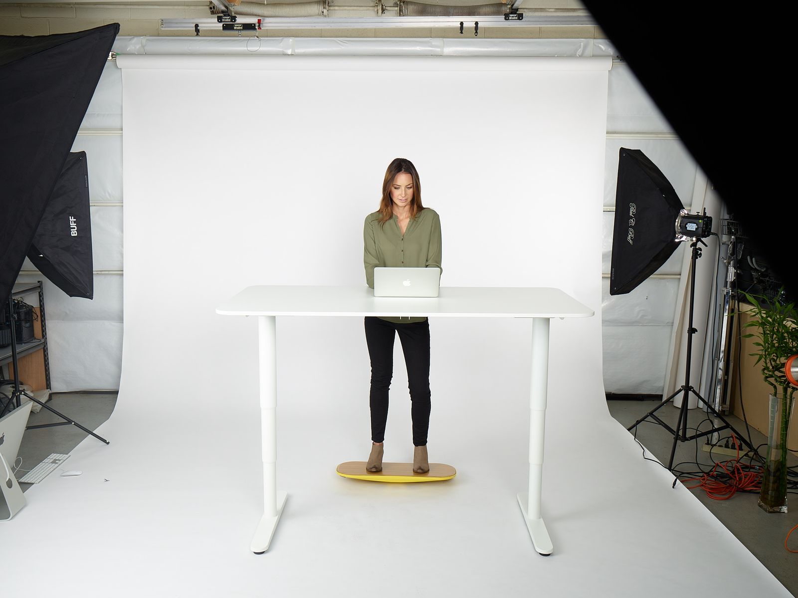 a woman standing at a table with a laptop
