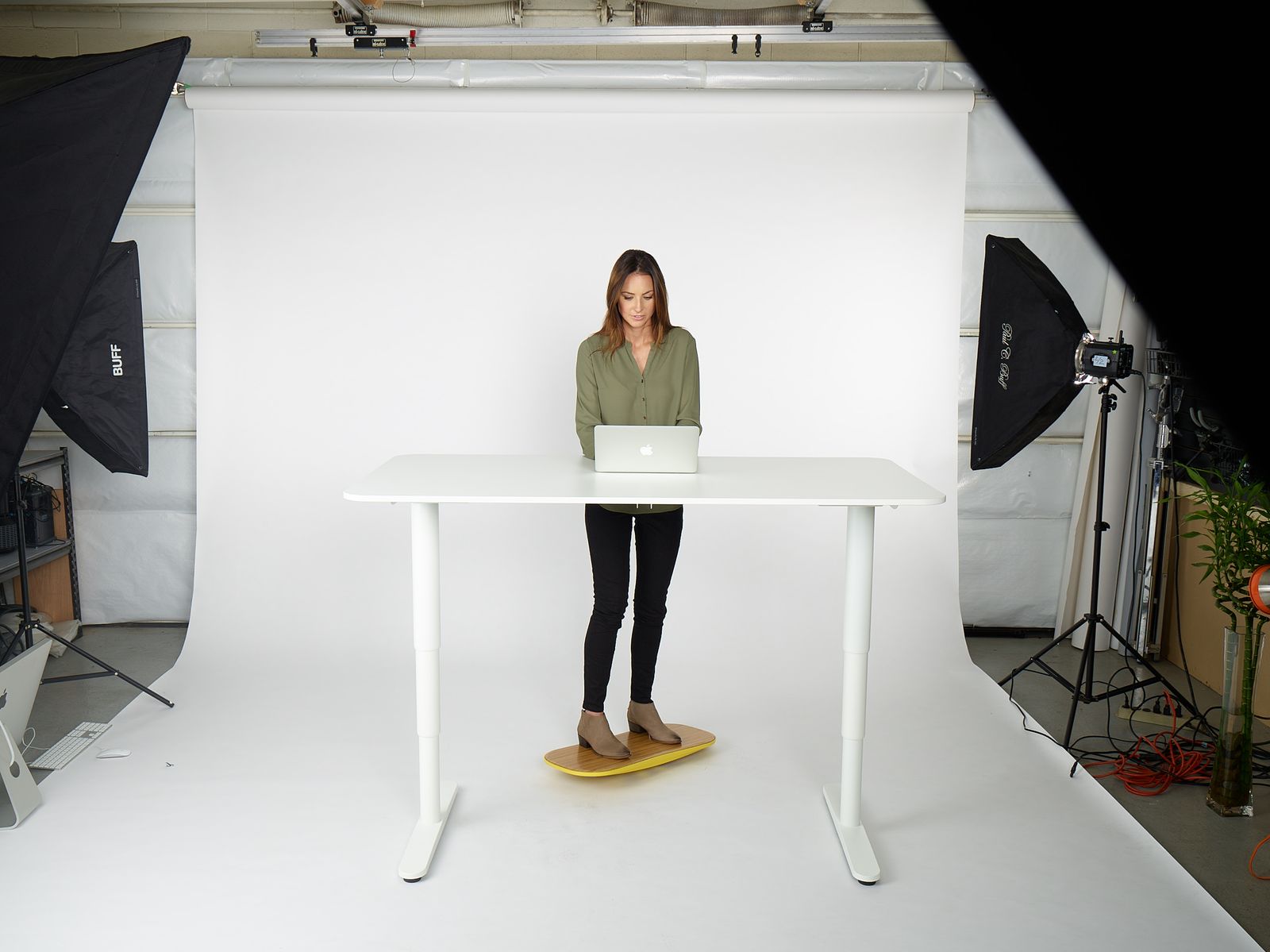 a woman standing at a table with a laptop