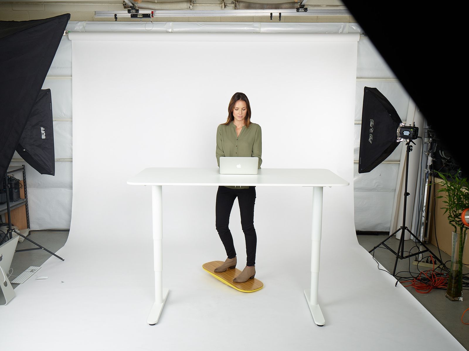 a woman standing in front of a laptop computer