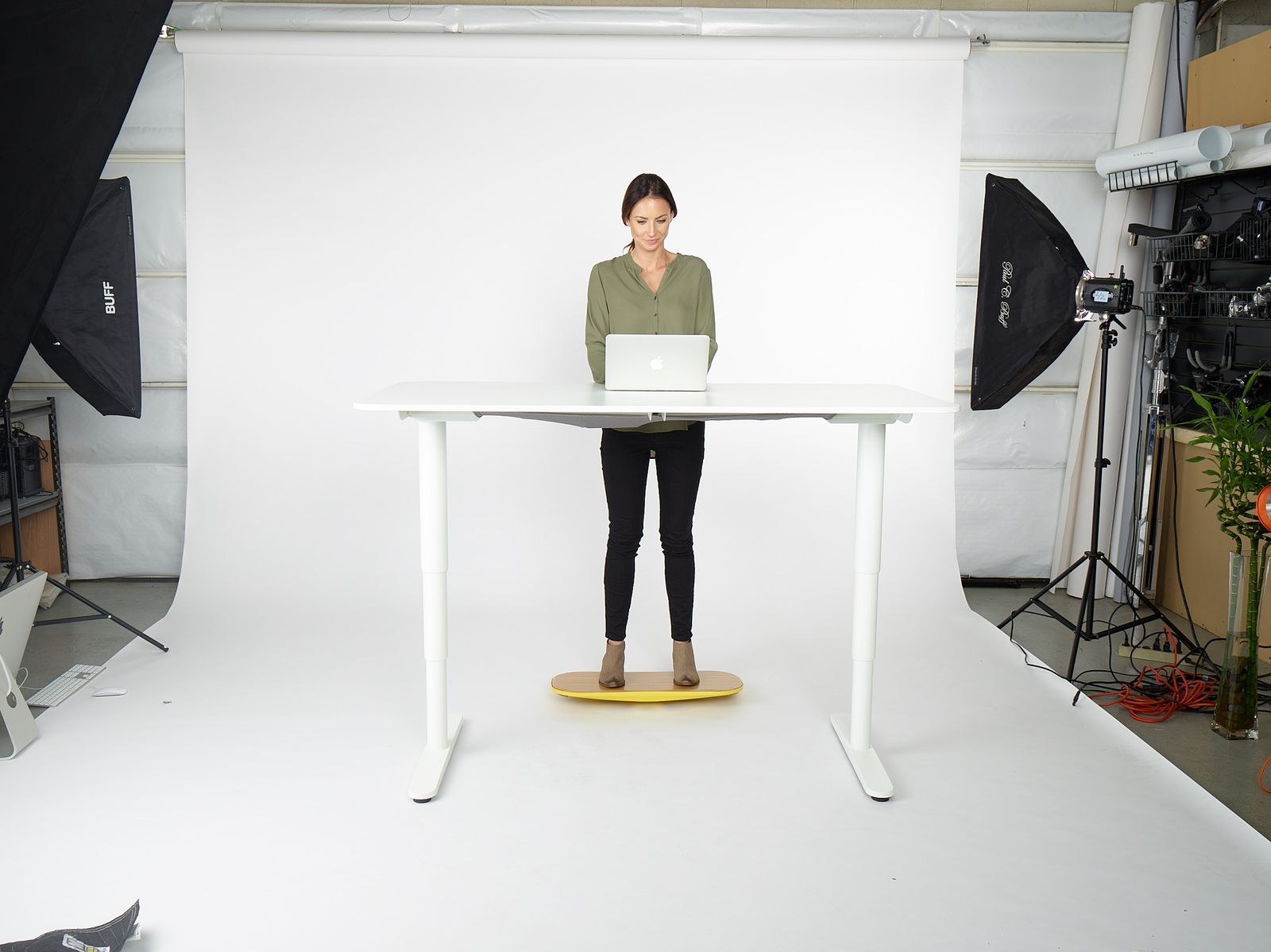 a woman standing in front of a laptop computer