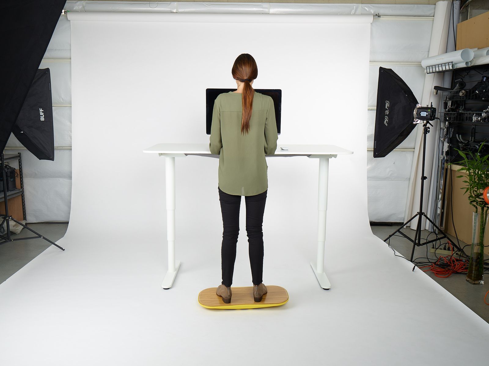 a woman standing at a desk in front of a camera