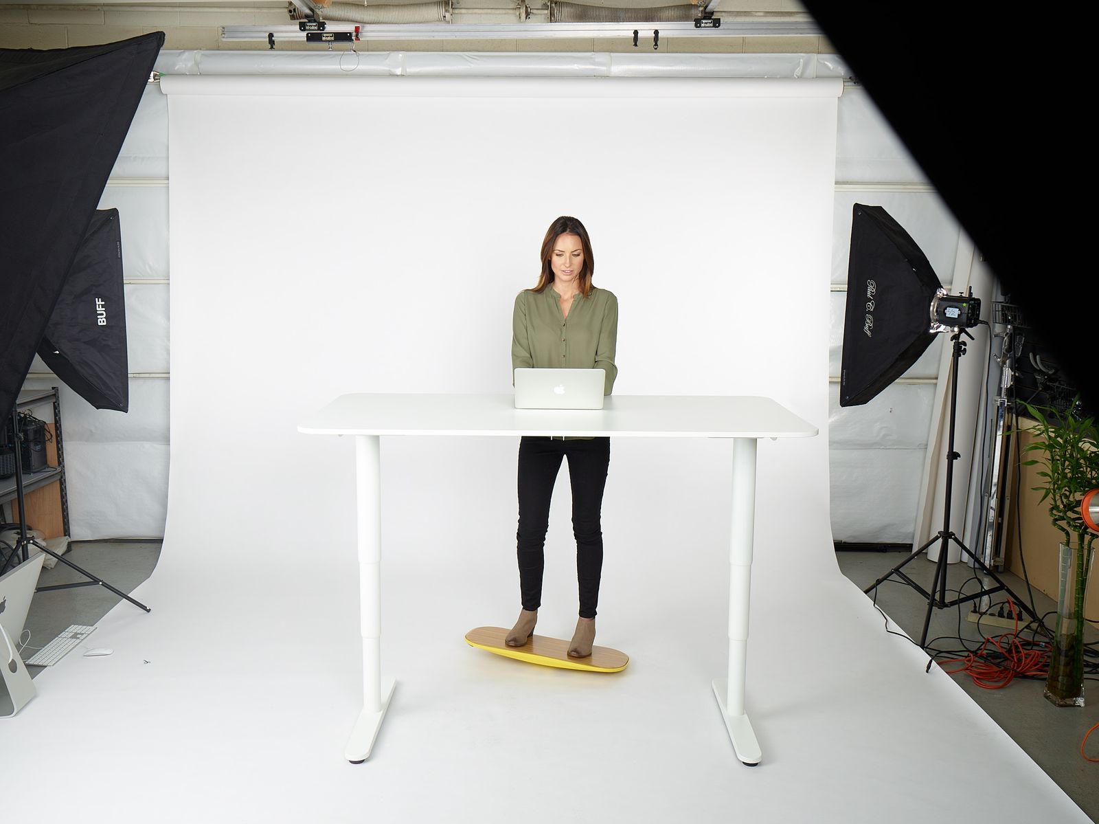 a woman standing at a table with a laptop