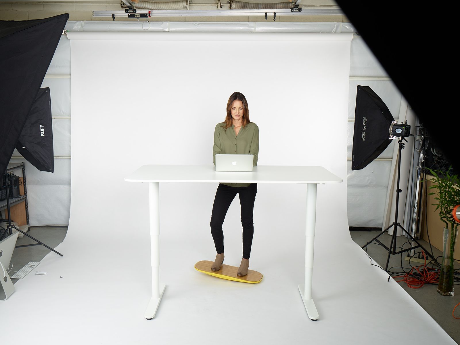 a woman standing at a table with a laptop