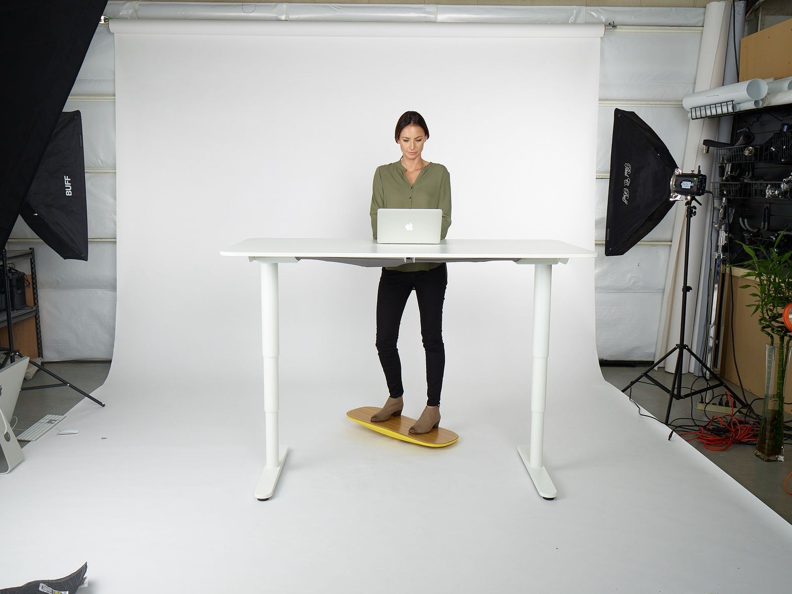 a woman standing in front of a laptop computer