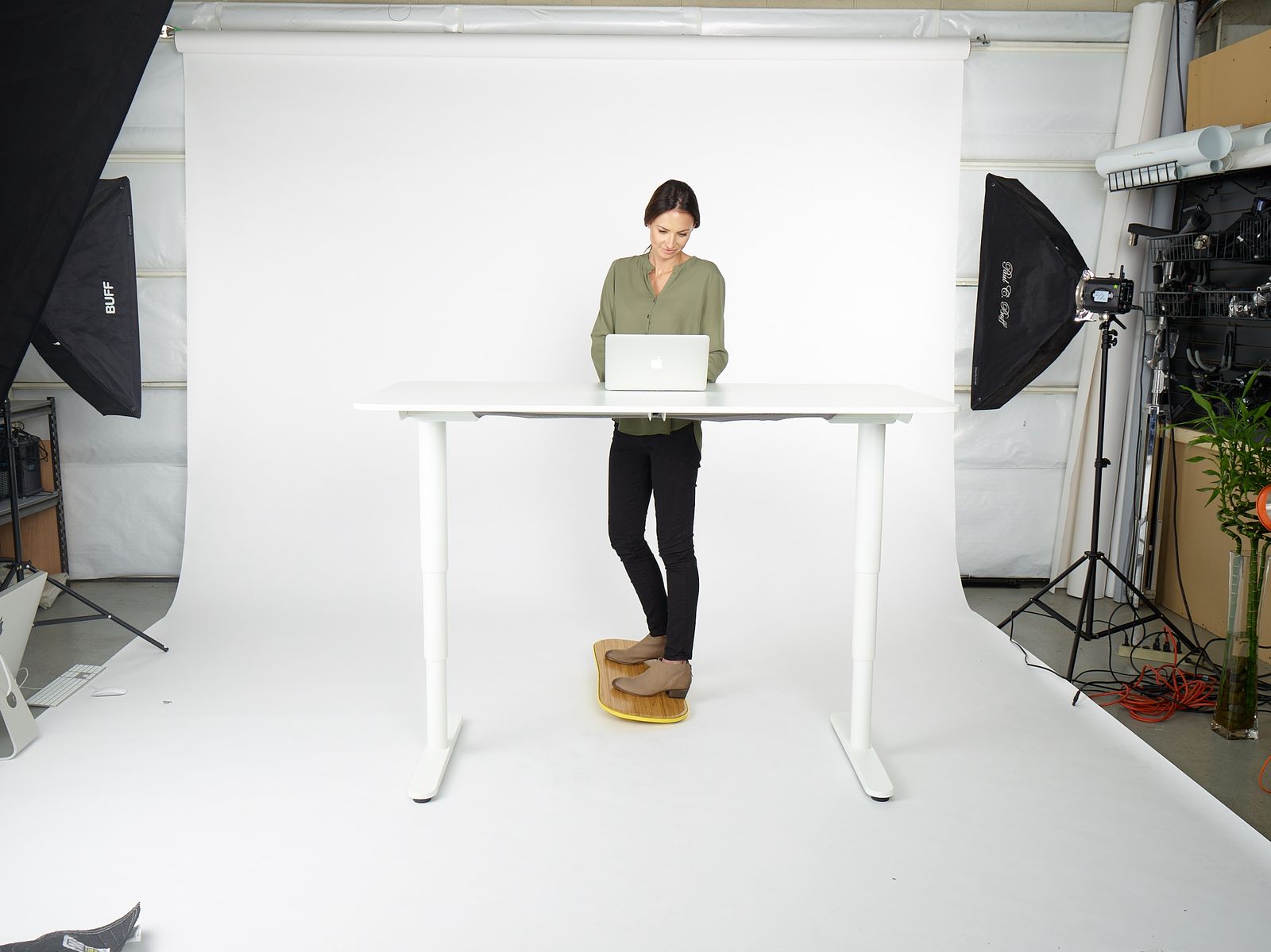 a woman standing at a table with a laptop