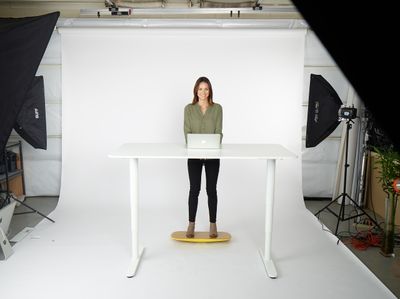 a woman standing at a table with a laptop