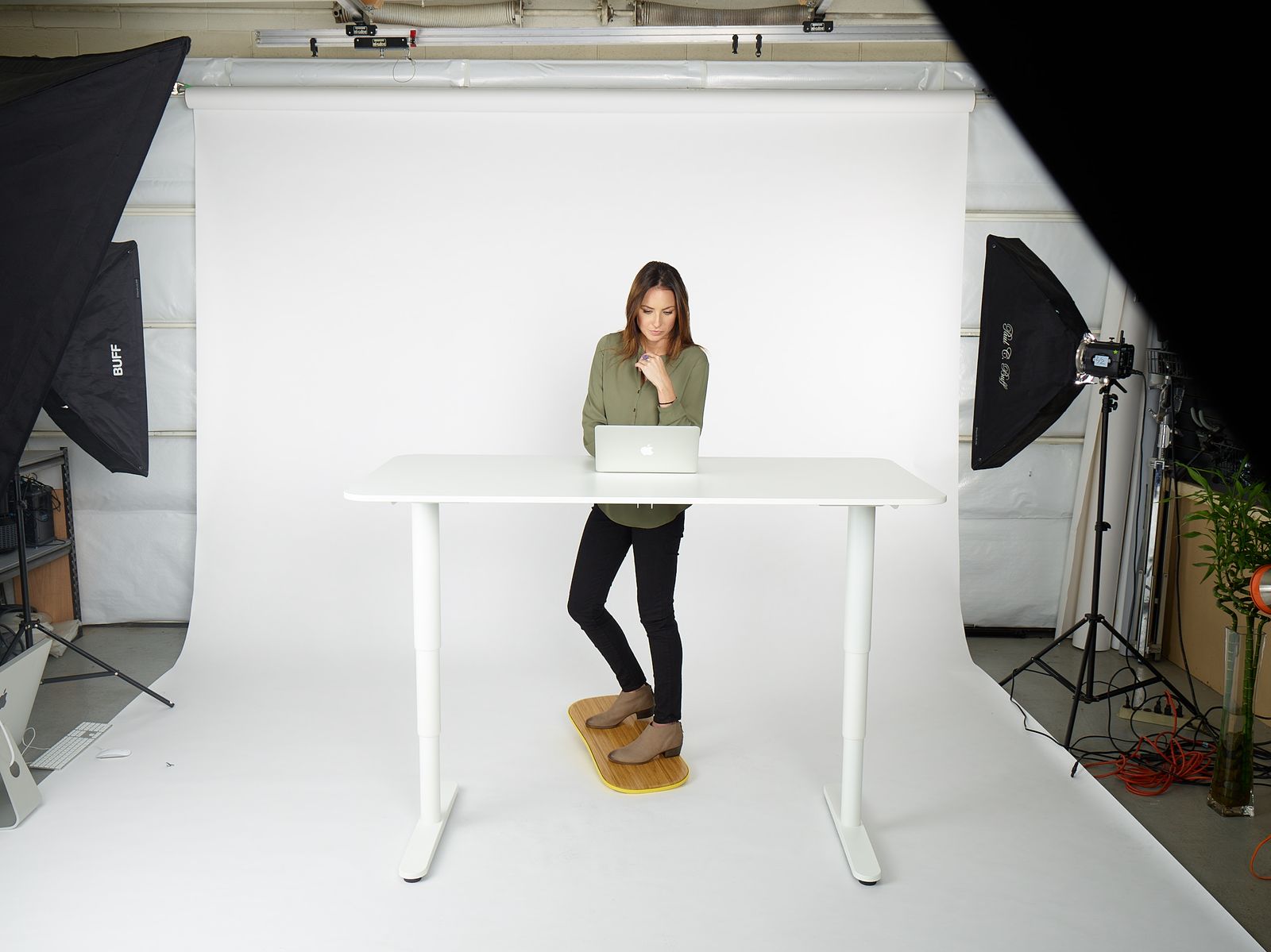 a woman standing in front of a laptop computer