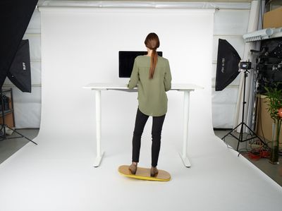 a woman standing in front of a white desk