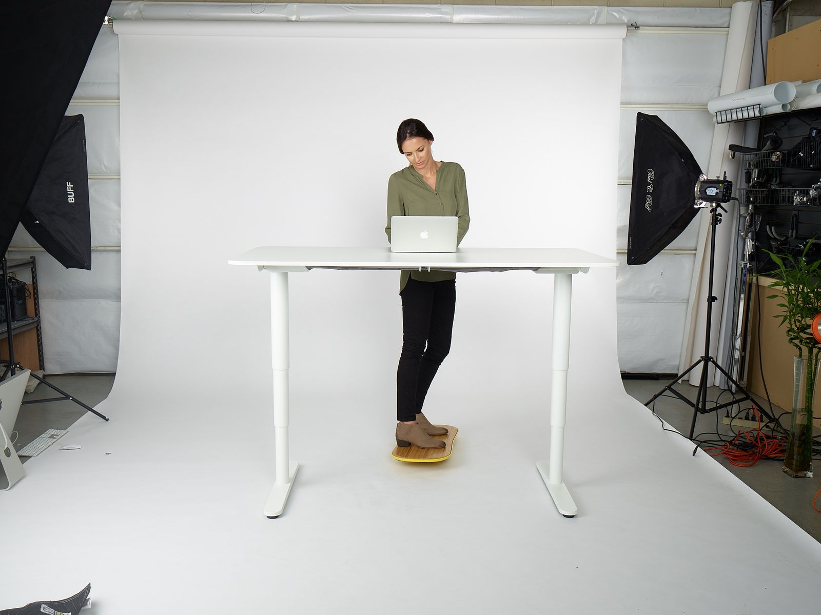 a woman standing at a table with a laptop