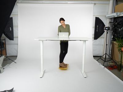 a woman standing at a table with a laptop