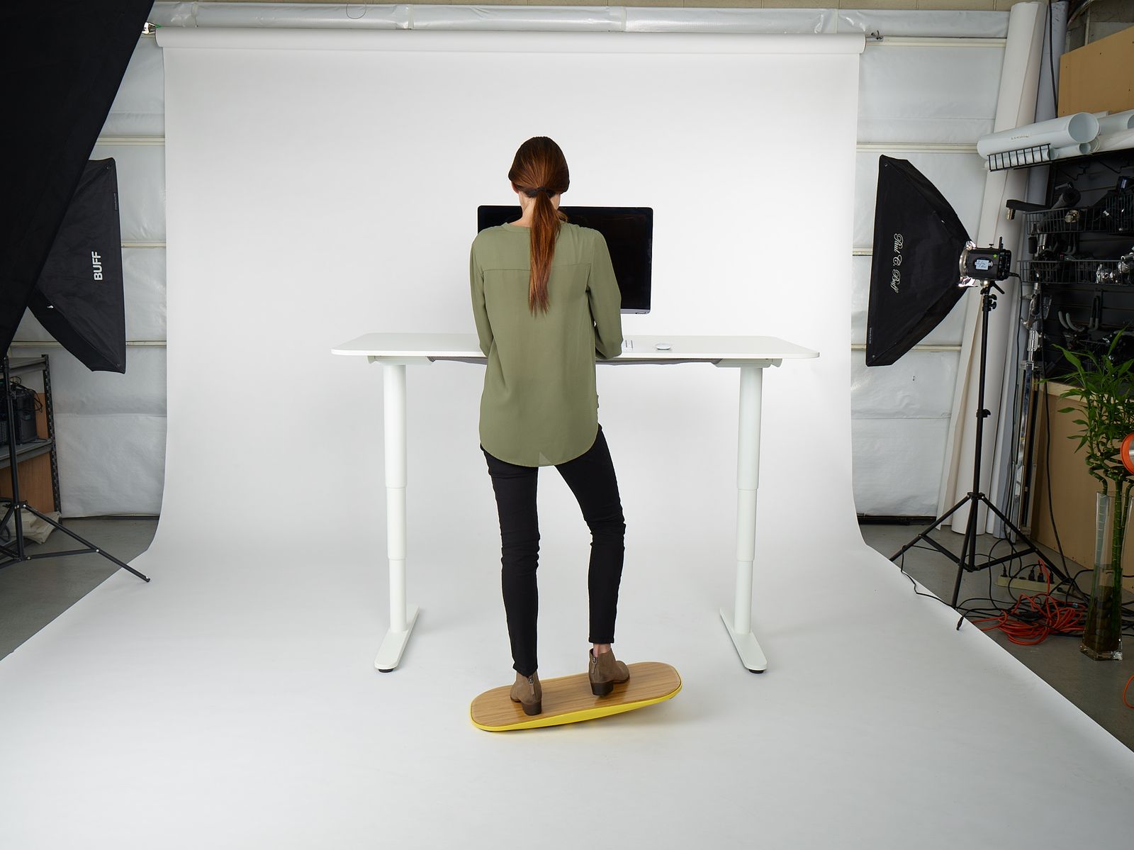 a woman standing on a surfboard in front of a desk