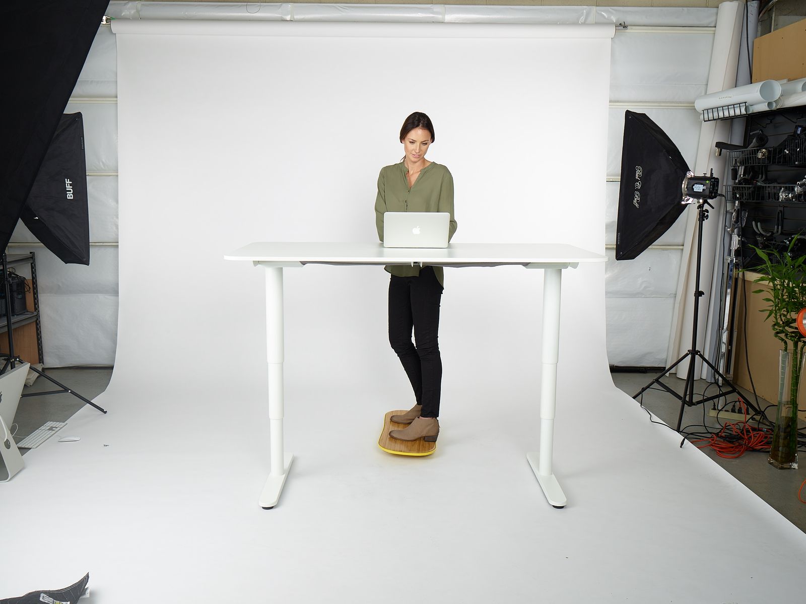 a woman standing at a table with a laptop