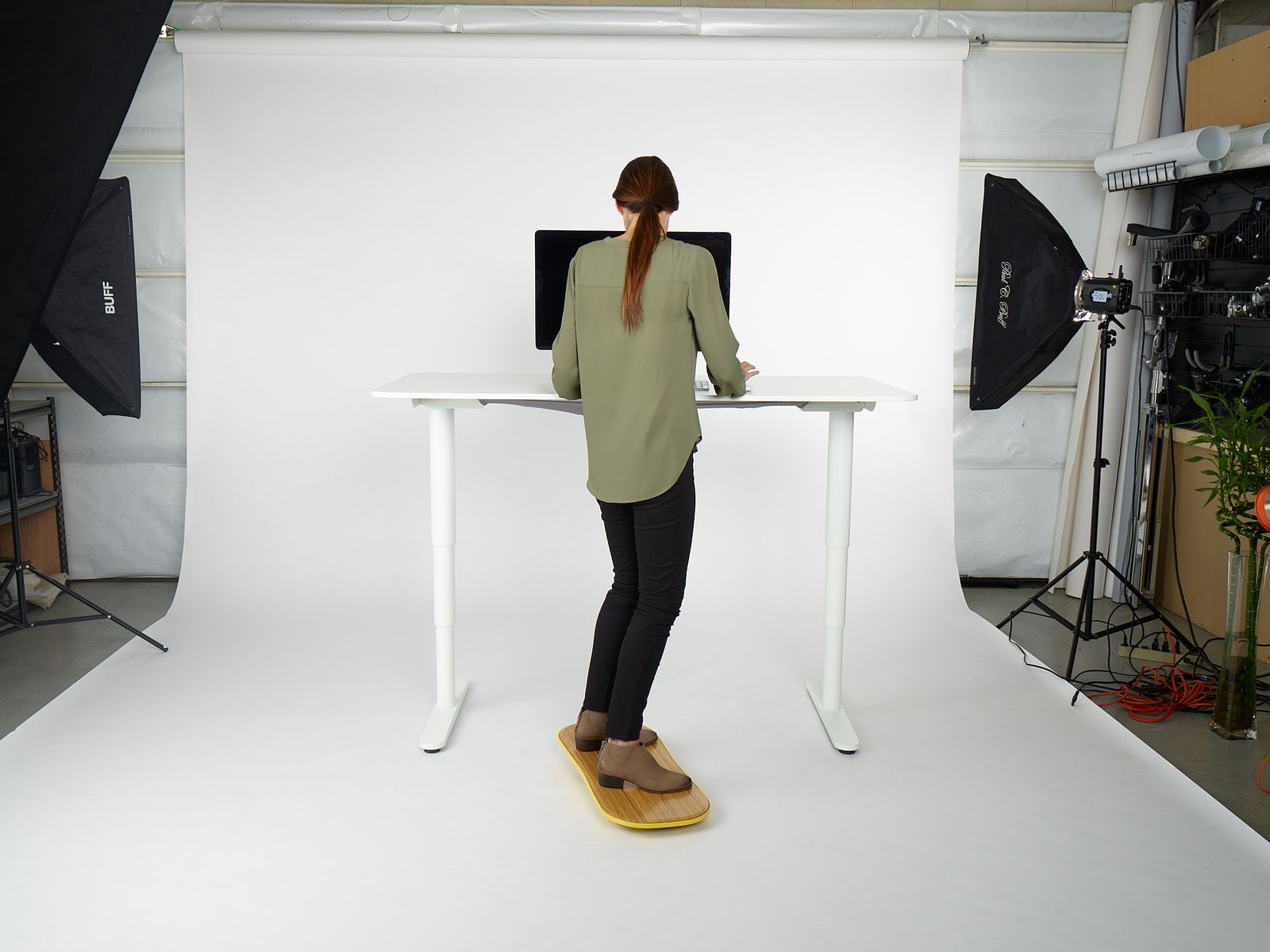 a woman standing at a desk in front of a camera